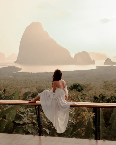 Woman with the white dress sit and see the mountain in early mor
